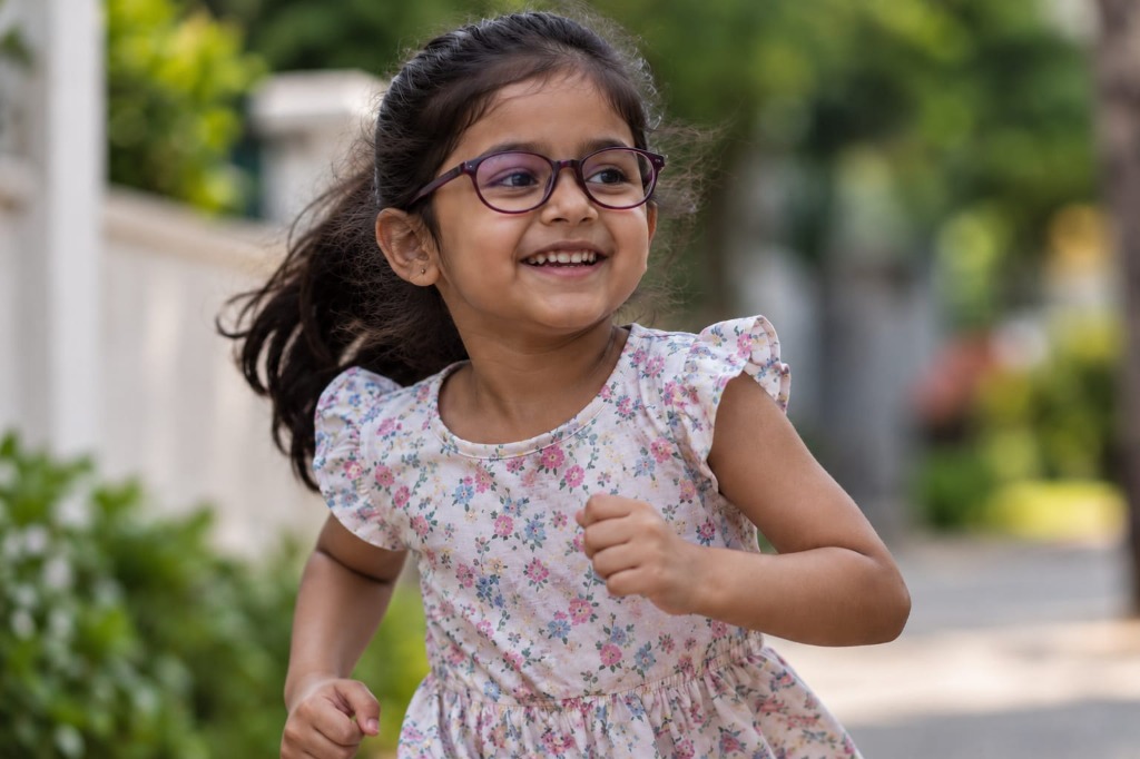Child wearing spectacles and enjoying clear vision outdoors